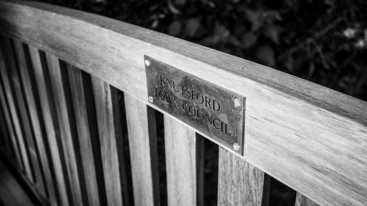 The top of a bench with a Knutsford Town Council plaque