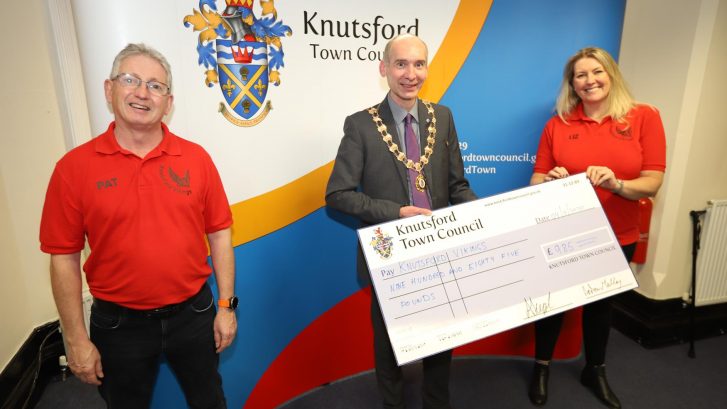 Town Mayor holds large cheque for a charity