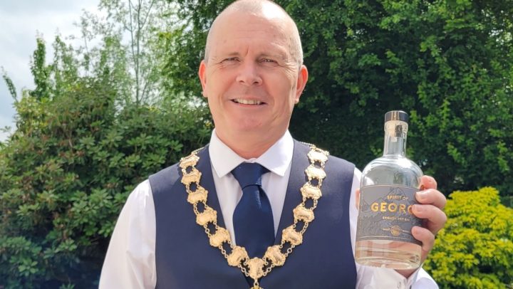 Mayor Mike Houghton holding a gin bottle