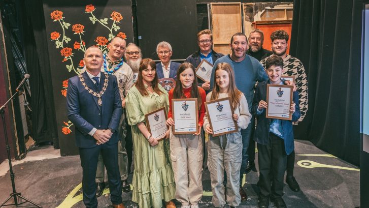 A group of people holding awards with the mayor