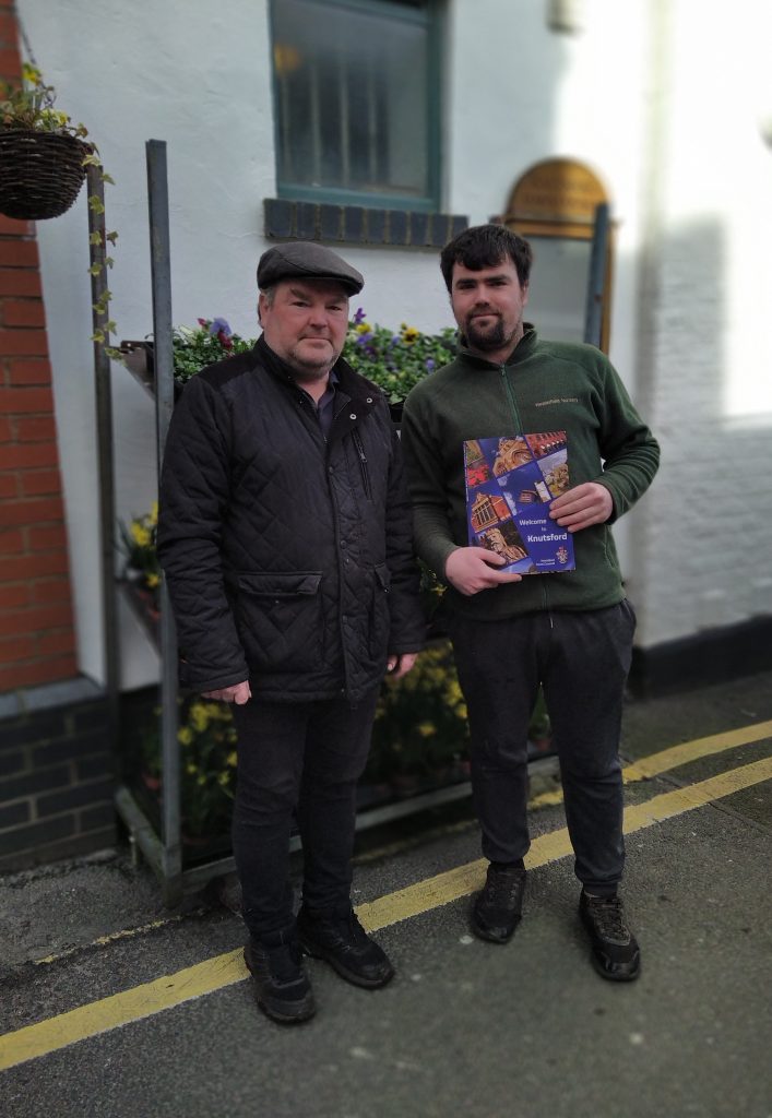 Two greengrocers stood by a bedding plant stall