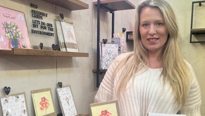 Sabrina Cowley of Its a Little Thing, standing in front of some cards
