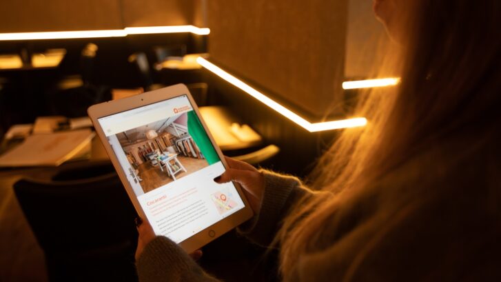 Someone holding an iPad showing Discover Knutsford Website