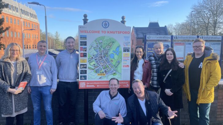 A group of people standing by a sign