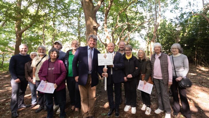 Town Mayor Cllr Bryan Hartley and Henry Brooks hold the new plaque with Friends of the Heath