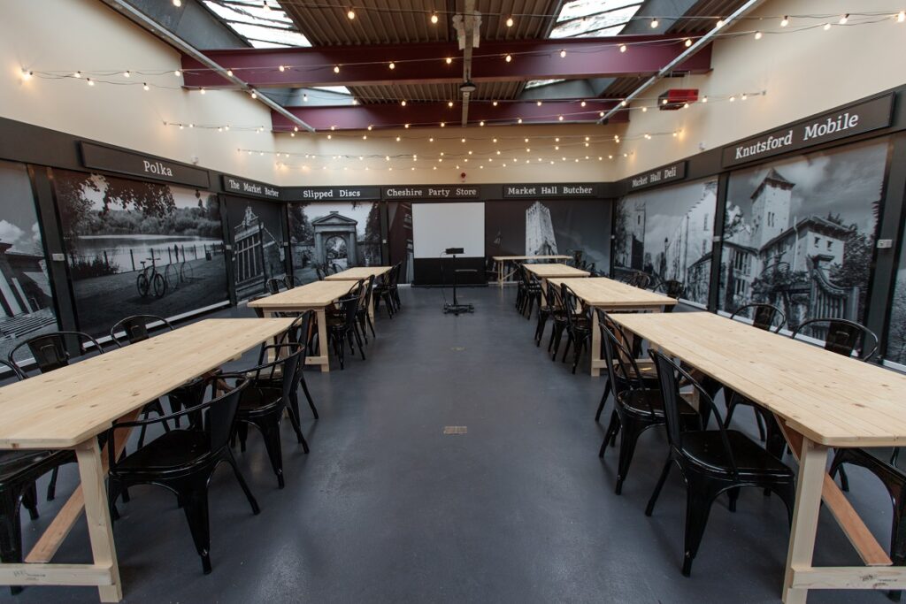 Knutsford Market Hall with tables and chairs and a projector