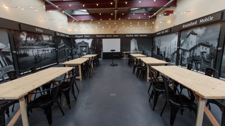 Knutsford Market Hall with tables and chairs and a projector