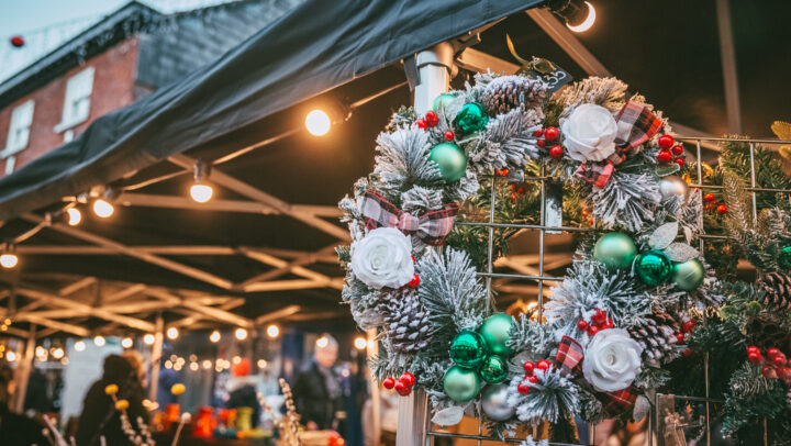 A christmas wreath hanging on the edge of a christmas market stall