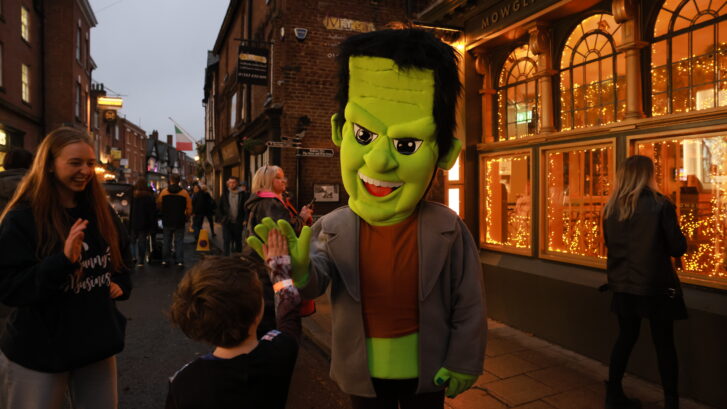 A Character of Frankenstein's Monster high fiving a pumkin path explorer!