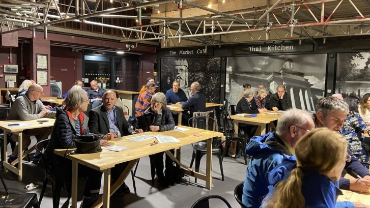 Tables of people discussing the town centre masterplan in Knutsford Market Hall