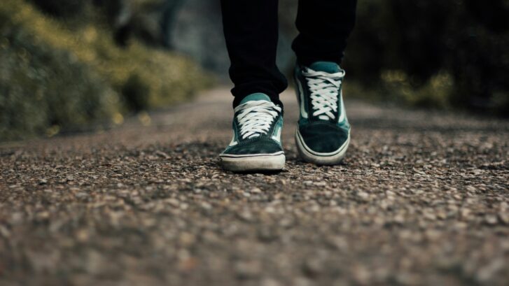 Two shoes walking on a road