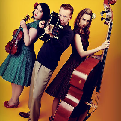 A man stood between two women, holding their instruments - Violin, Guitar and Cello. 