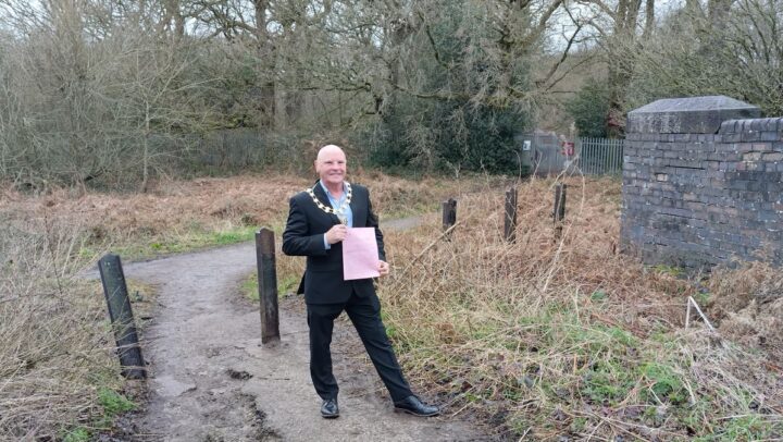 The Mayor of Knutsford holding a pink form on a public footpath