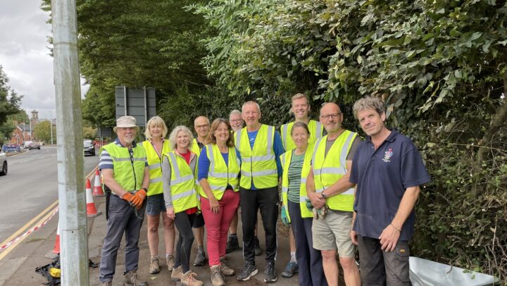 A group of people along the footway cleared of debris and vegetation