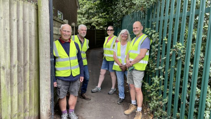 A group of volunteers standing on a public footpath