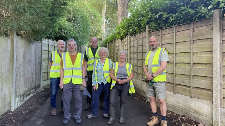 A group of people in high viz jackets on a local footpath